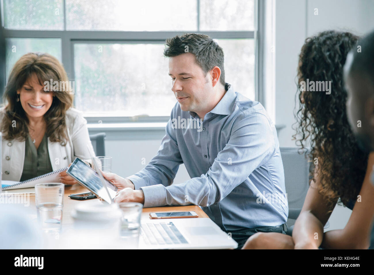 Business people using digital tablet in meeting Stock Photo