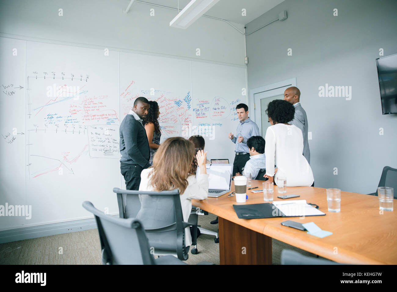 Businessman talking near whiteboard in meeting Stock Photo
