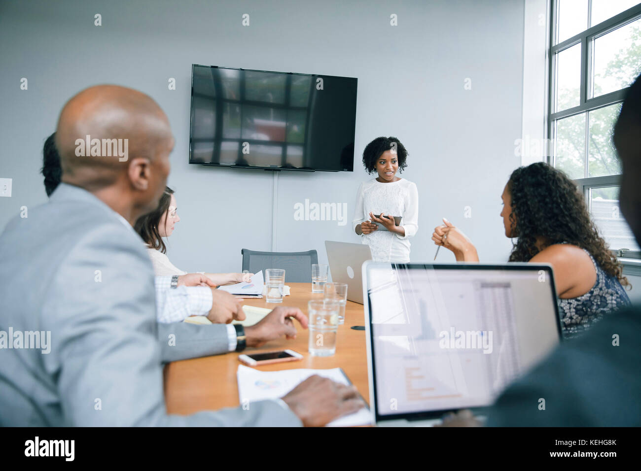 Businesswoman talking near visual screen in meeting Stock Photo
