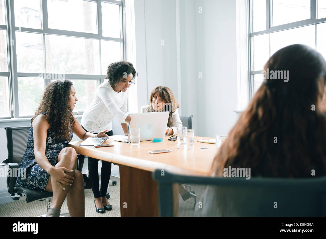 Businesswomen using laptop in meeting Stock Photo