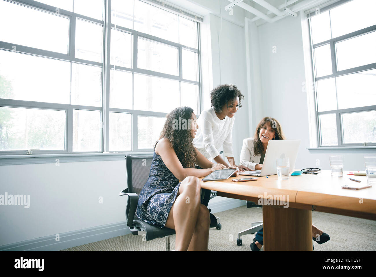 Businesswomen using laptop in meeting Stock Photo