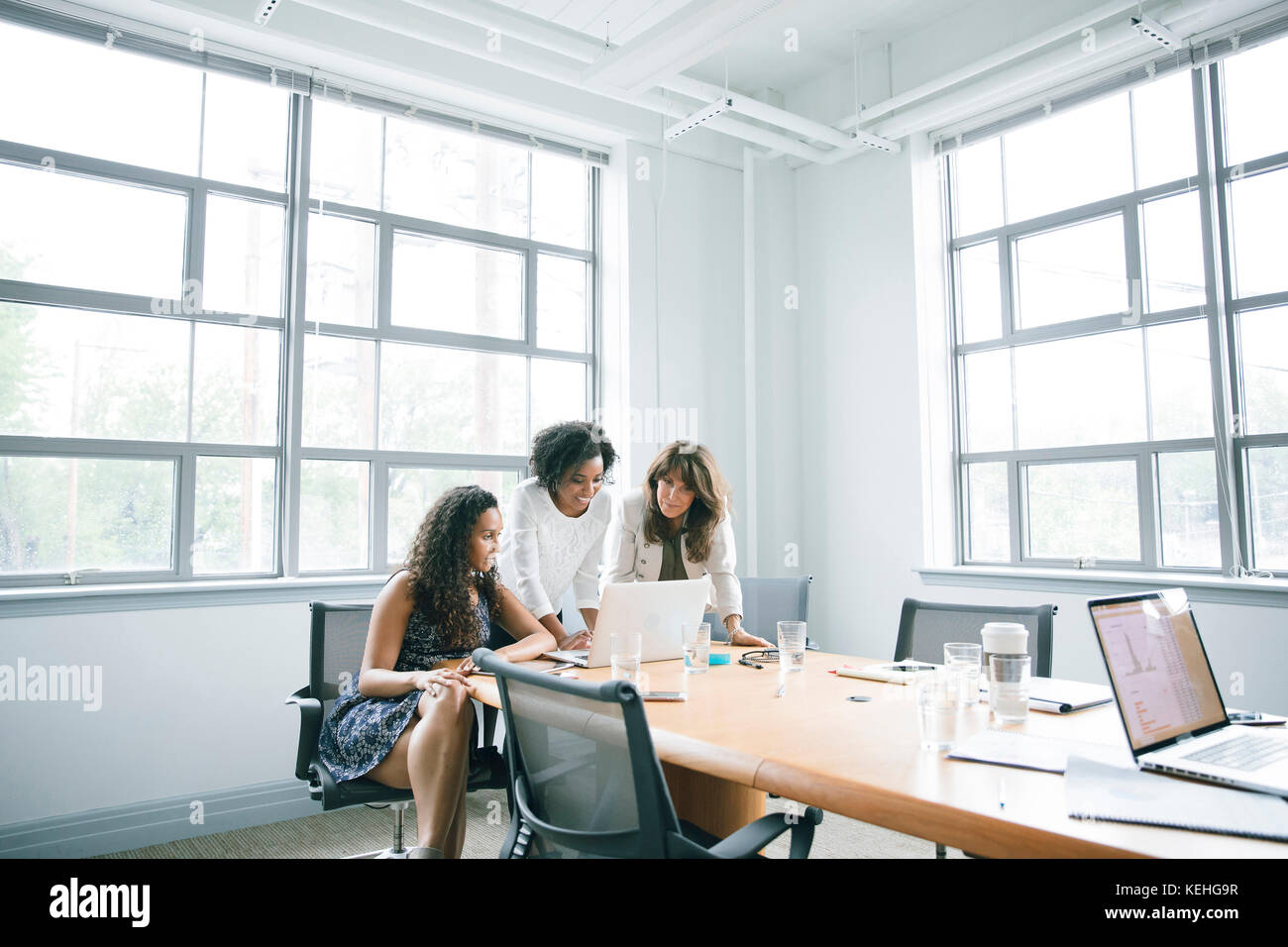 Businesswomen using laptop in meeting Stock Photo