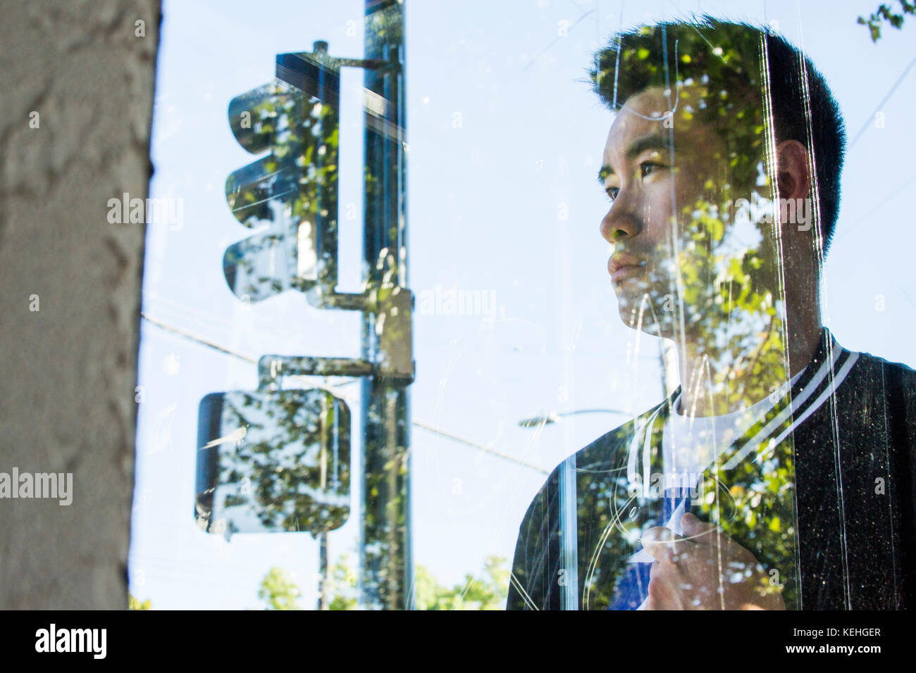 Portrait of serious Chinese man behind window Stock Photo