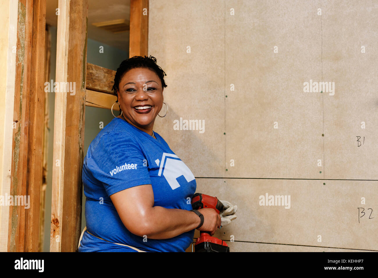 Portrait of smiling black woman holding drill Stock Photo