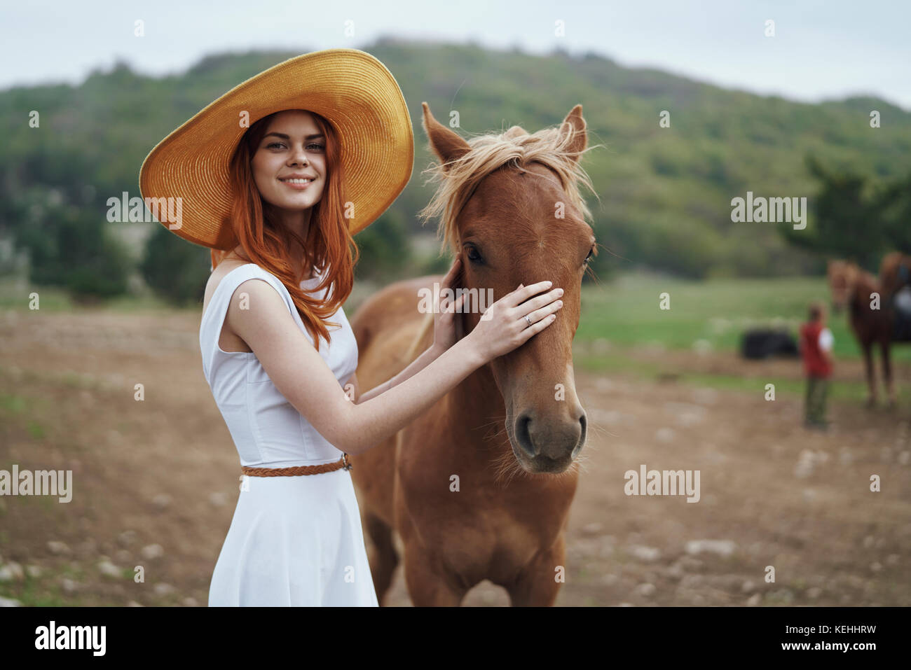 Smiling woman petting horse Stock Photo