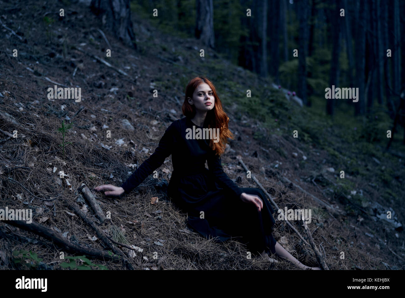 Caucasian woman sitting on hill Stock Photo