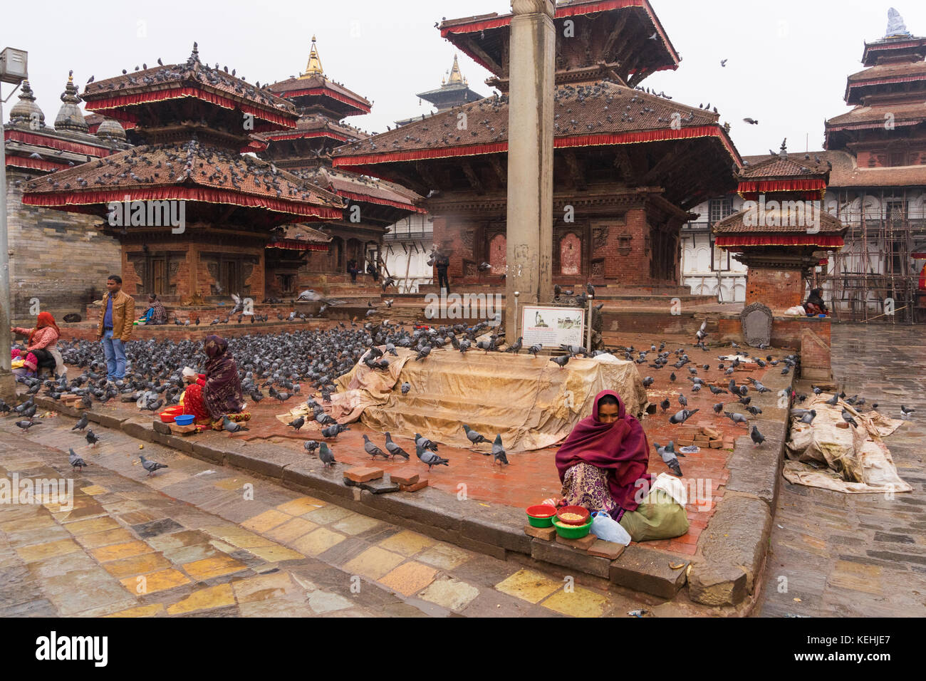 Nepali women selling corn grain to feed the pigeons at Durbar Square, Kathmandu. Stock Photo