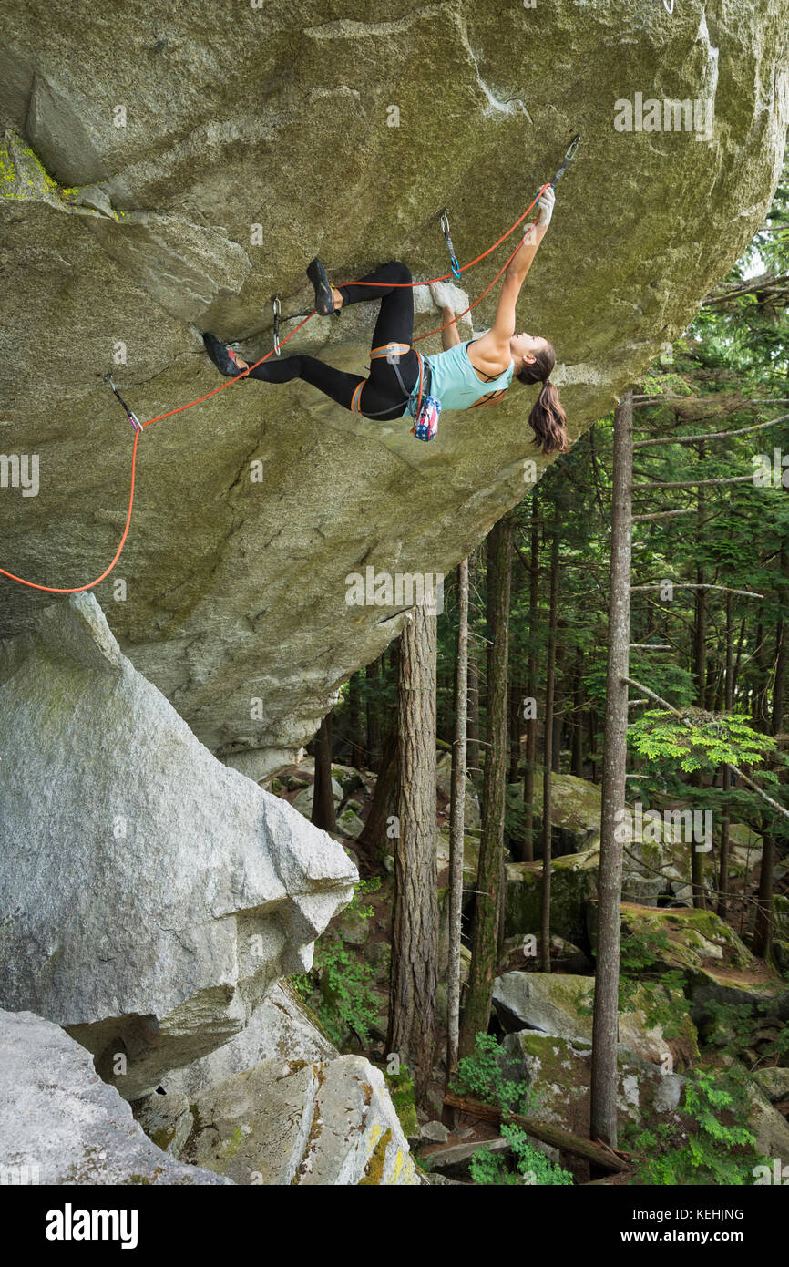 Mixed race girl climbing rock Stock Photo