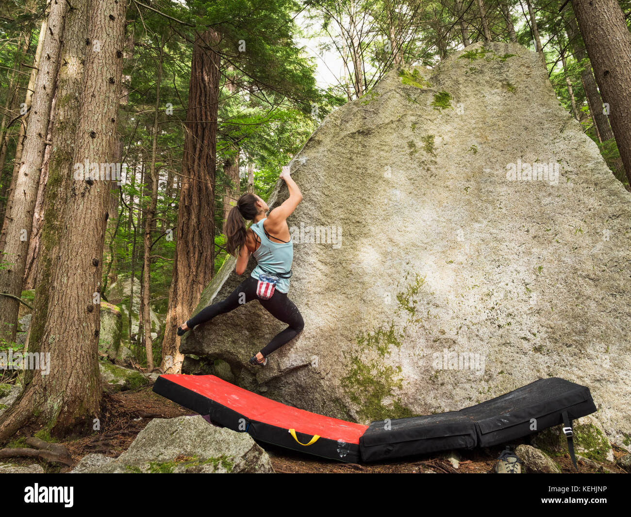 Mixed race girl climbing rock Stock Photo