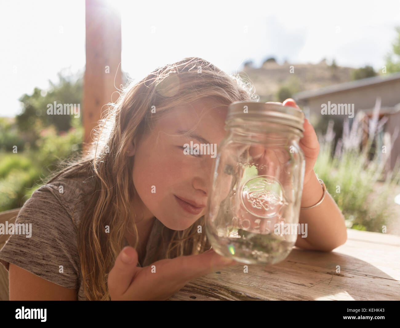 Caucasian girl looking at jar Stock Photo