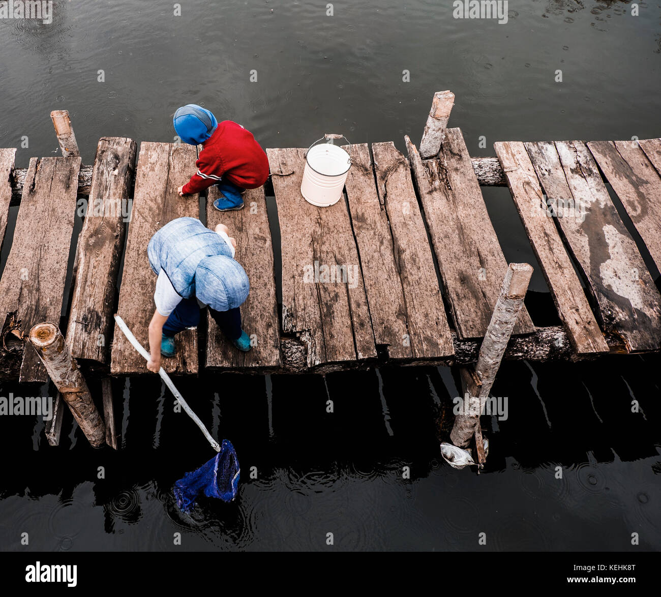 Boys playing on wooden dock Stock Photo