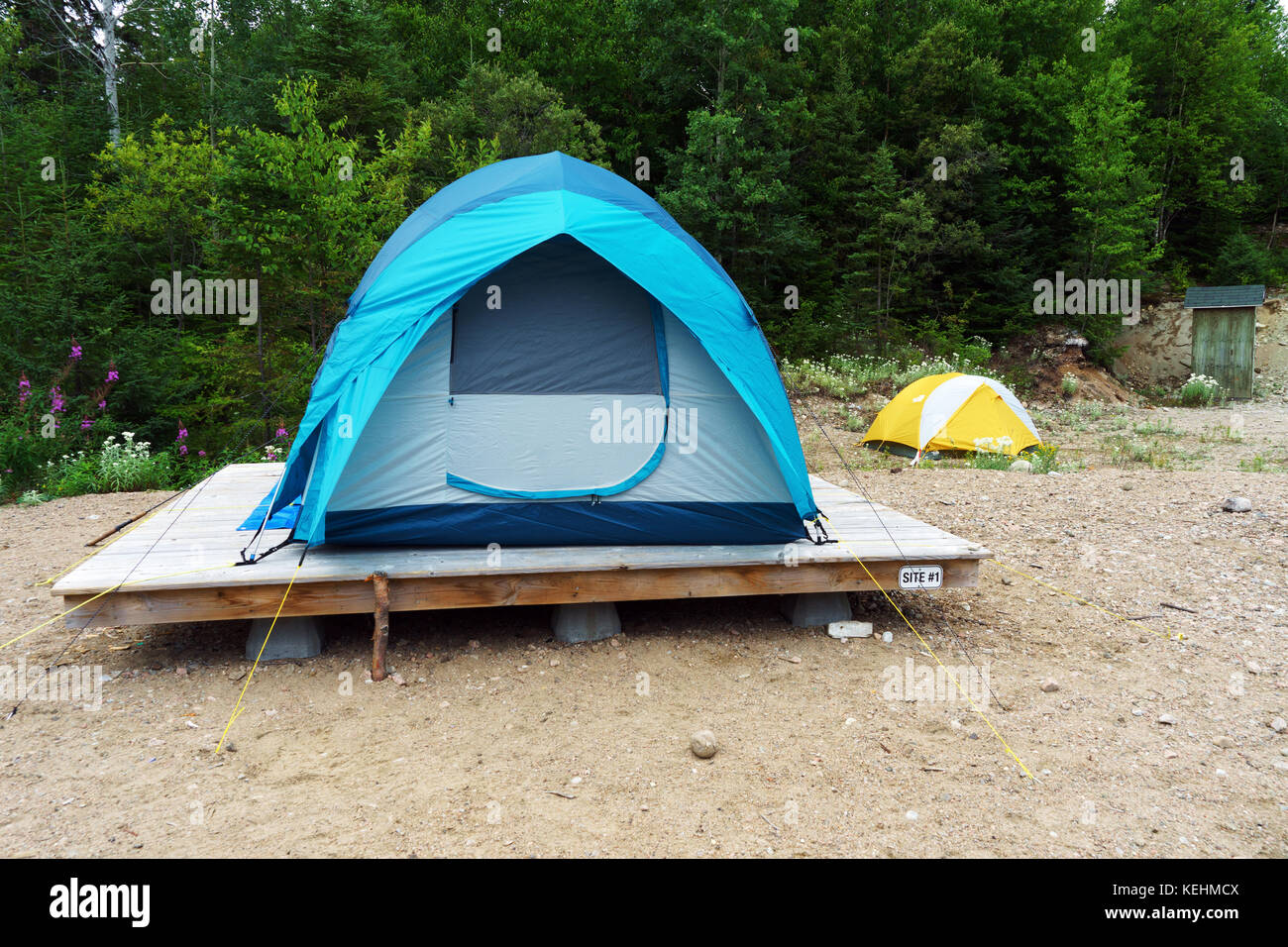 Tent pitched on a wooden platform. Stock Photo
