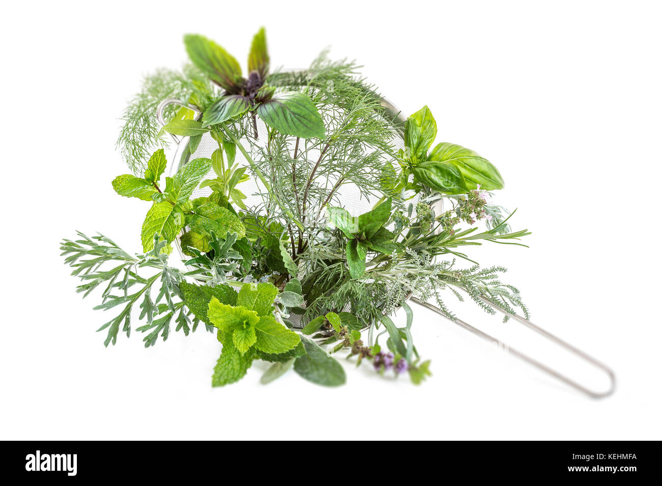 Various herbal tea fresh herbs in a metal sieve on white background Stock Photo