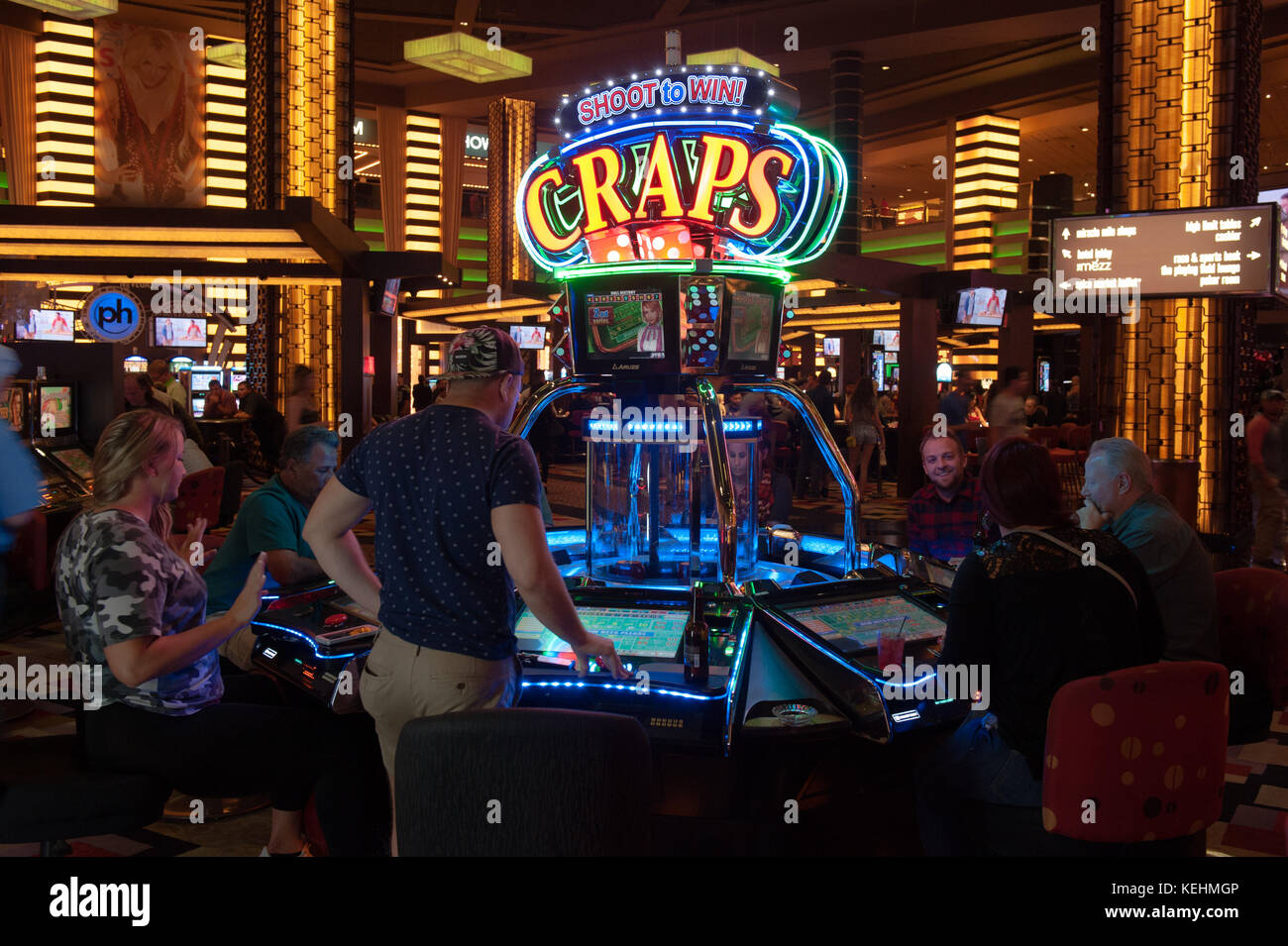 Gamblers playing Craps on a Shoot to Win machine, Planet Hollywood casino, Las Vegas, Nevada. Stock Photo