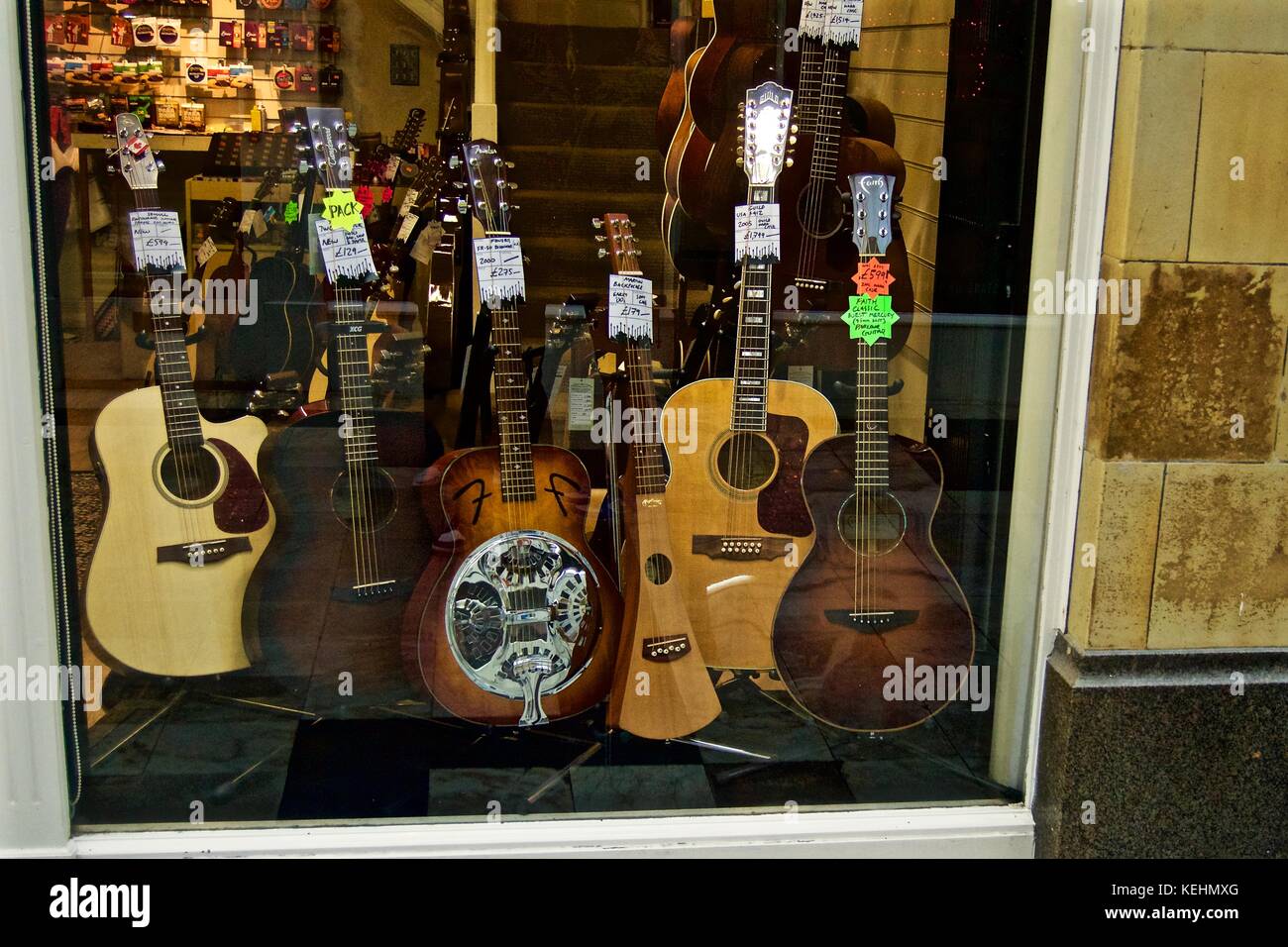 Guitars on sale in shop window, Royal Arcade, Worthing, UK Stock Photo