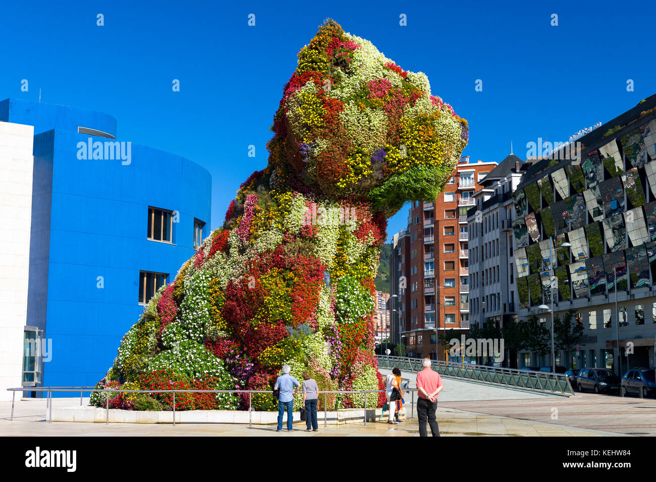 Tourists at Puppy by Jeff Koons floral art in dog form at Guggenheim Museum by Silken Gran Hotel Domine in Bilbao, Spain Stock Photo