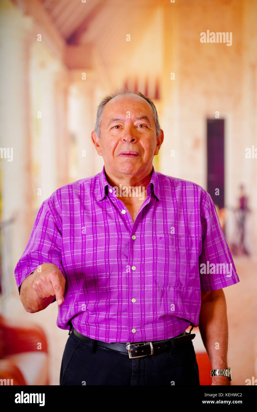 Close Up Of A Happy Old Man Pointing With His Hand To Down And Wearing