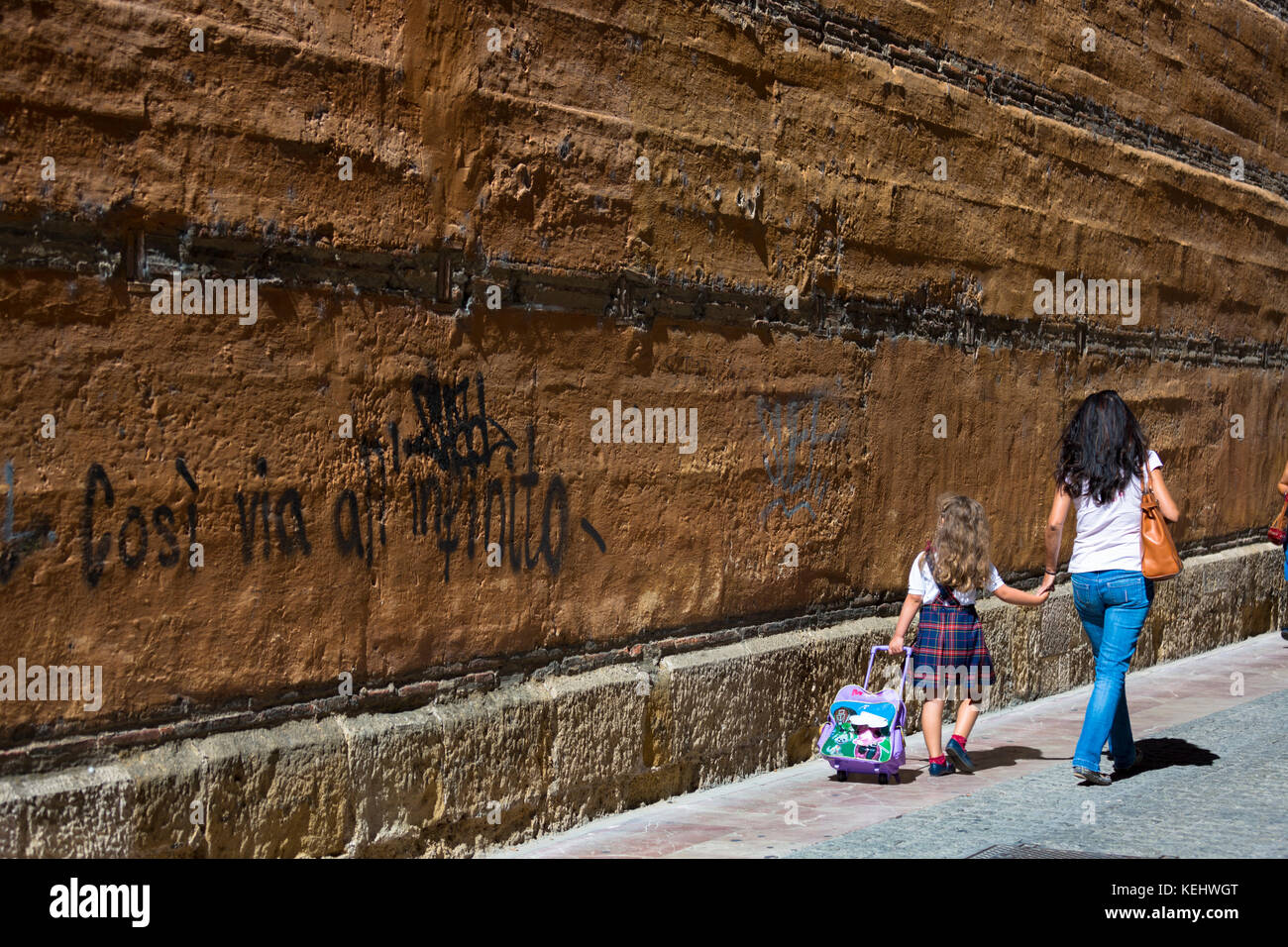 Spanish woman taking child to school in Calle Sacramento in Leon, Castilla y Leon, Spain Stock Photo