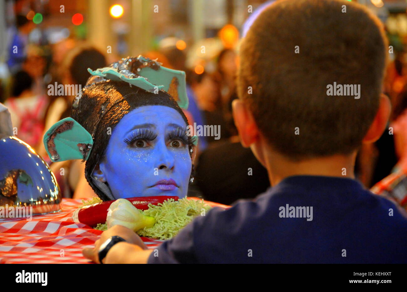 Boy surprised to see a face served on a plate during custume festival Stock Photo
