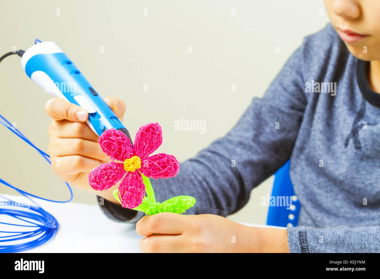 Kids hands making flower with 3d printing pen Stock Photo - Alamy