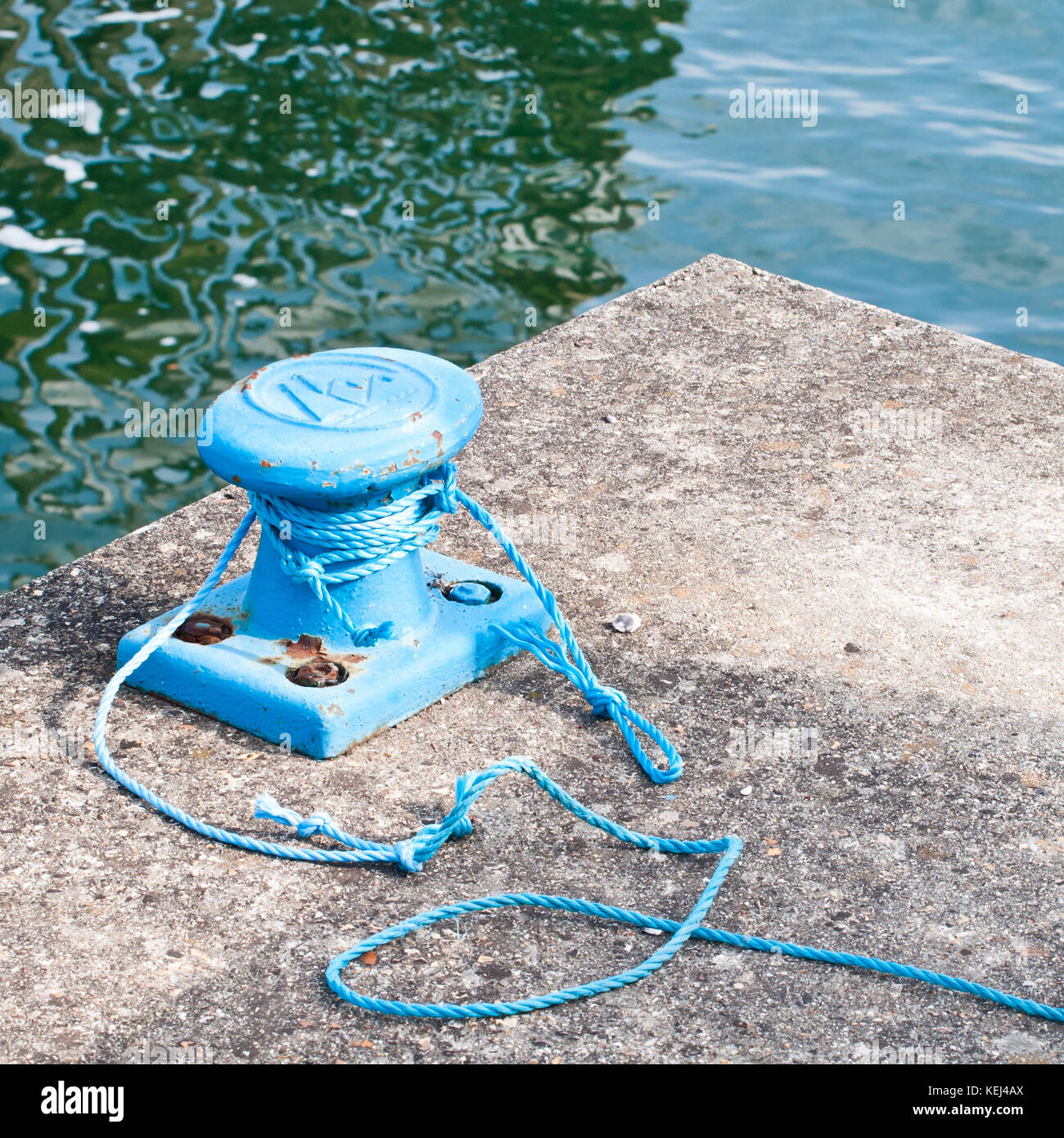 A shot of some blue rope tied around a mooring at the marina. Stock Photo