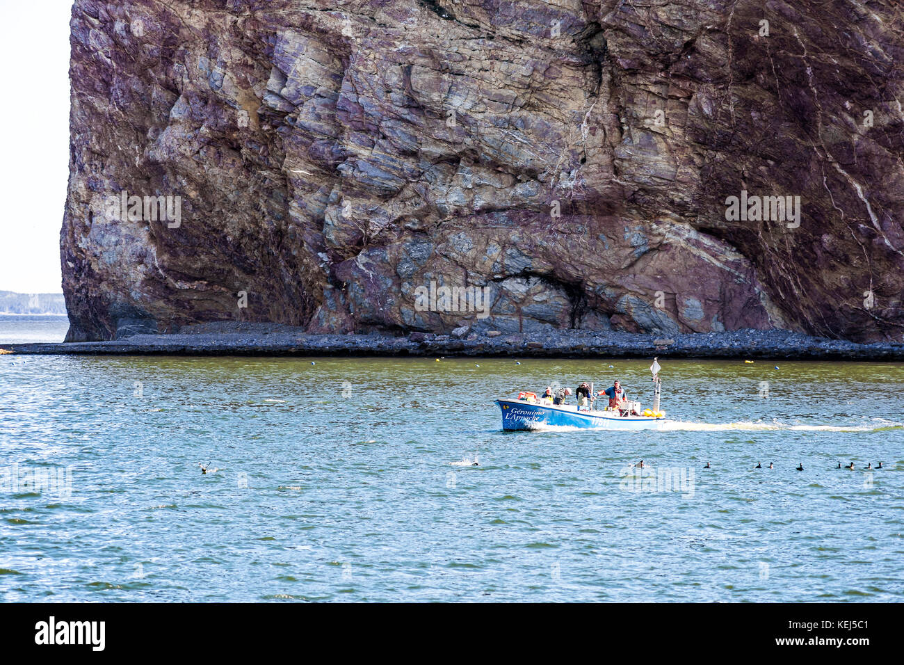 Perce, Canada June 6, 2017 Fishing boat with sign swimming by Rocher Perce rock and