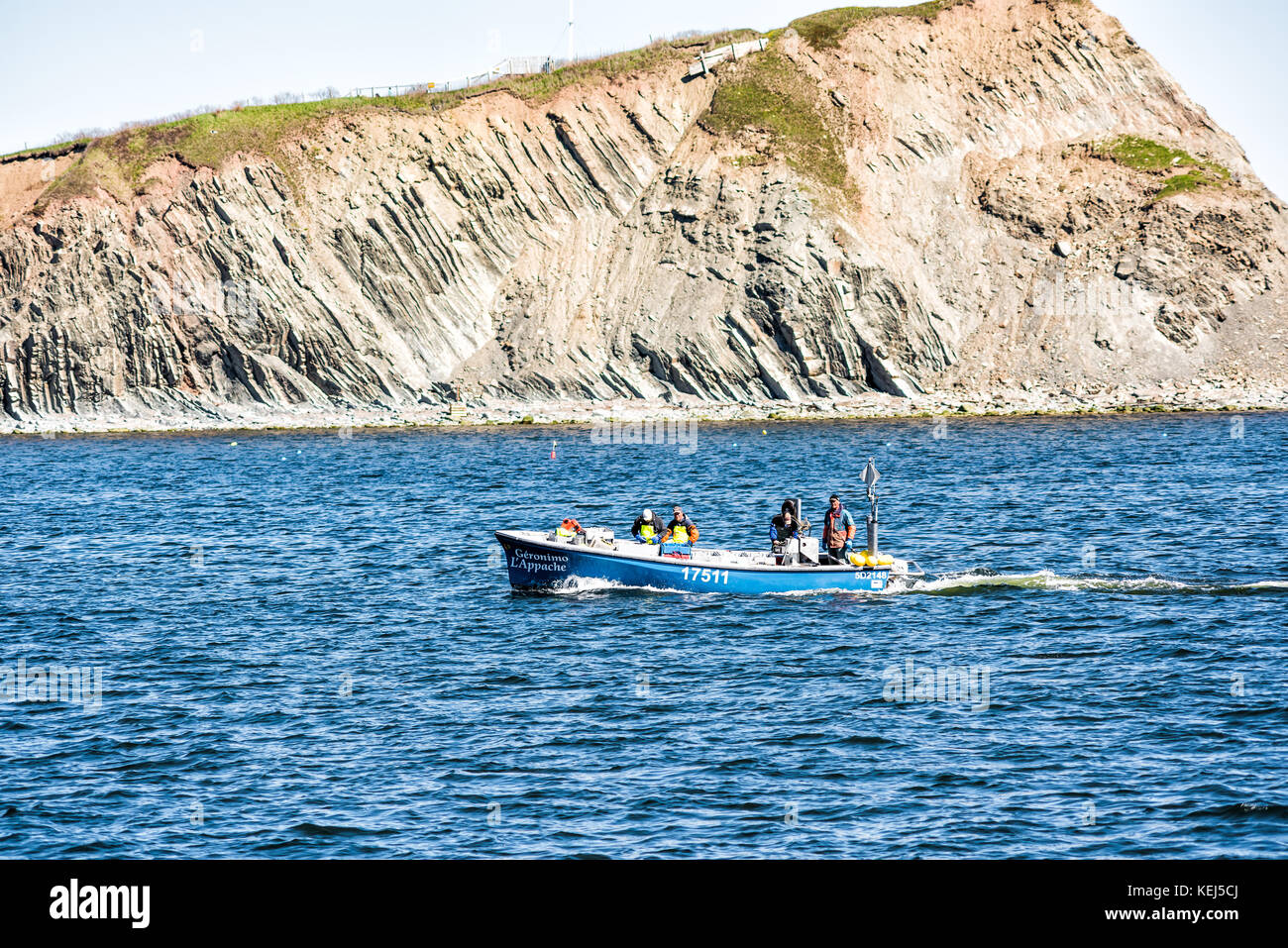 Perce, Canada June 6, 2017 Fishing boat with sign swimming by Rocher Perce rock and
