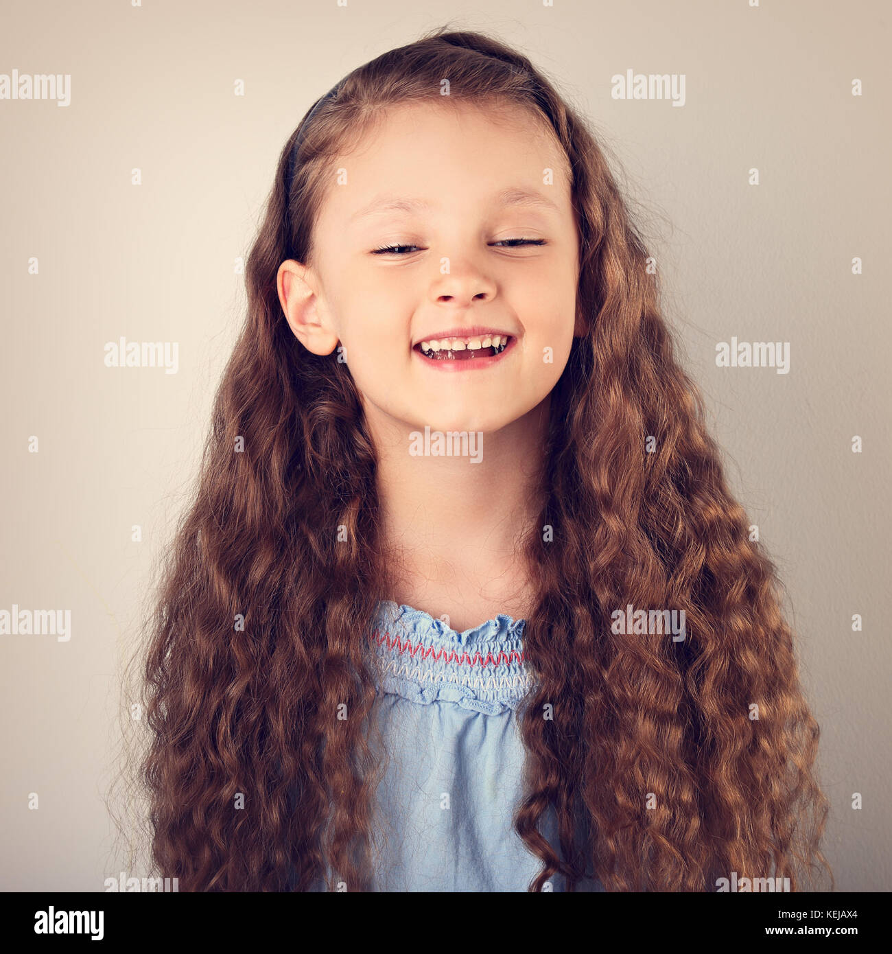 Beautiful natural expression laughing kid girl looking with long
