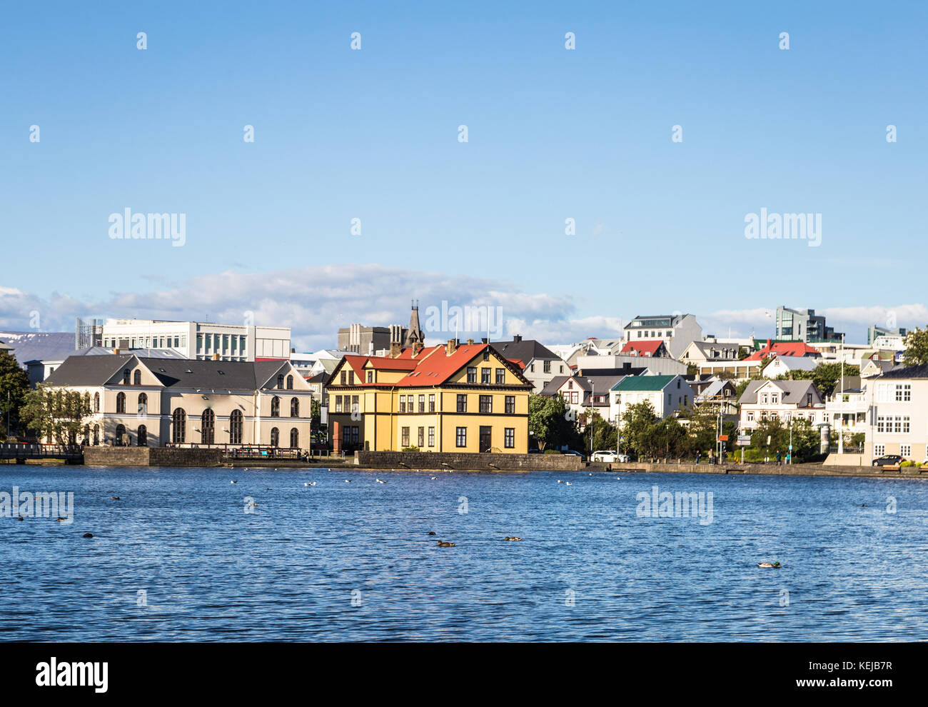 Reykjavik cityscape viewed from across the Tjornin lake in the heart of Iceland capital city on a sunny summer day. Stock Photo