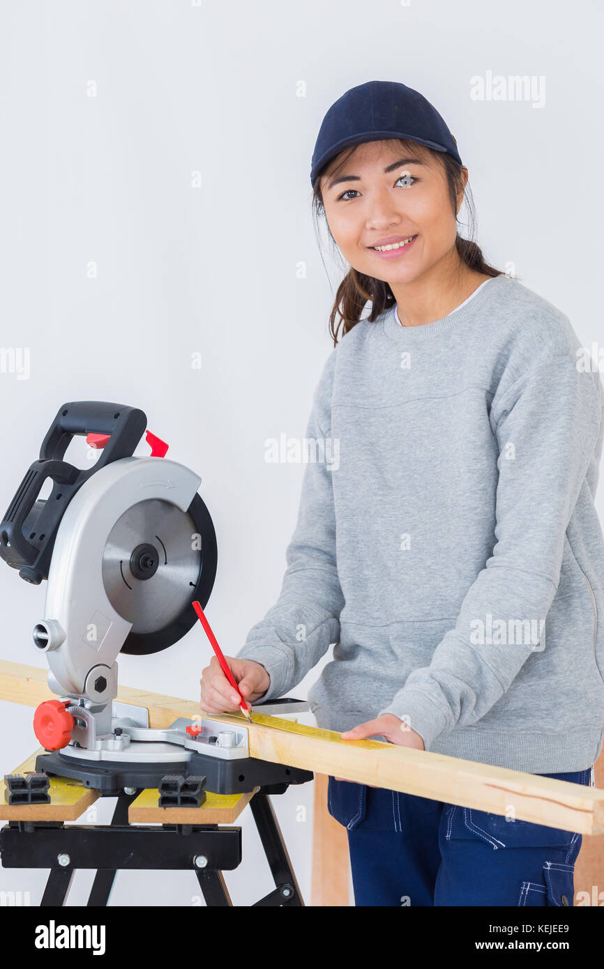 female apprentice using circular saw in carpentry workshop Stock Photo