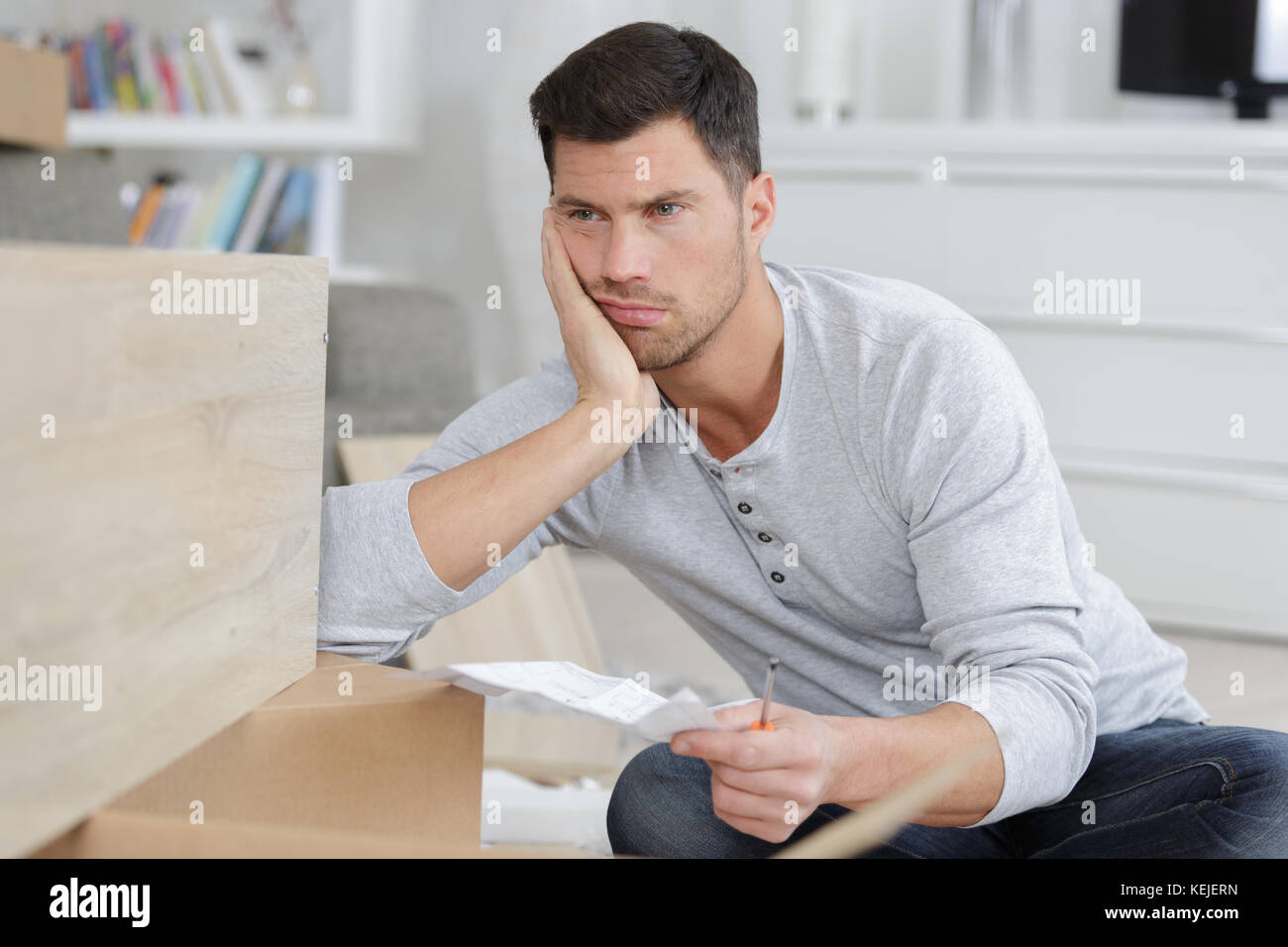 frustrated man holding instructions for assembling furniture Stock ...