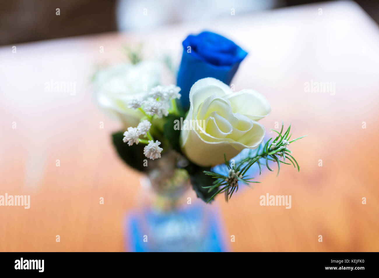 Close up of blue and white roses as a table decoration in a small glass ...