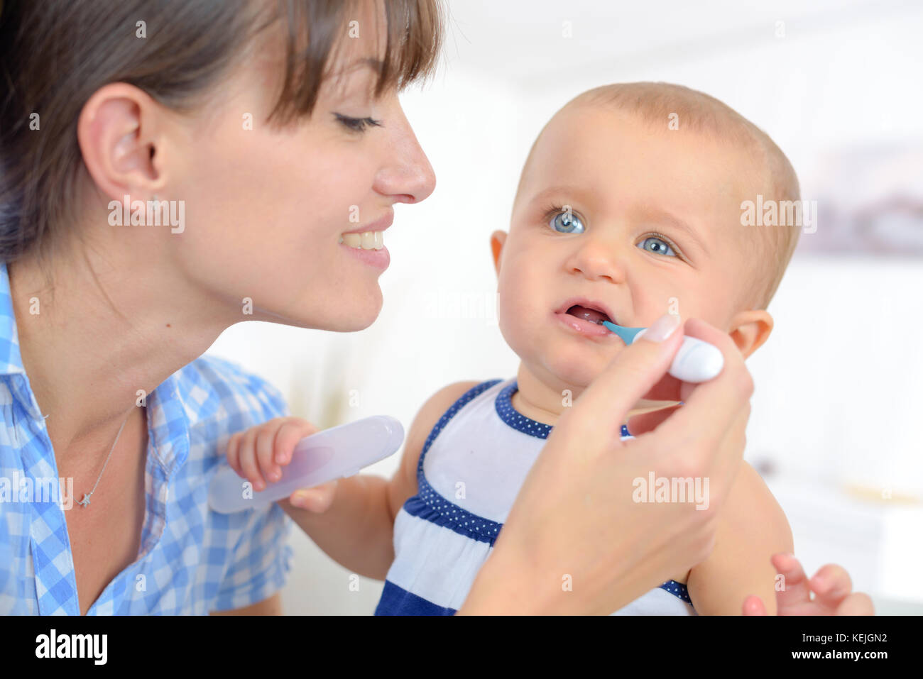mother measures the temperature of a baby child Stock Photo