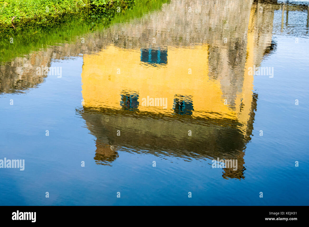 Stogursey Castle, Somerset. Reflected in the moat is the early 17th century cottage built among the ruins. Stock Photo