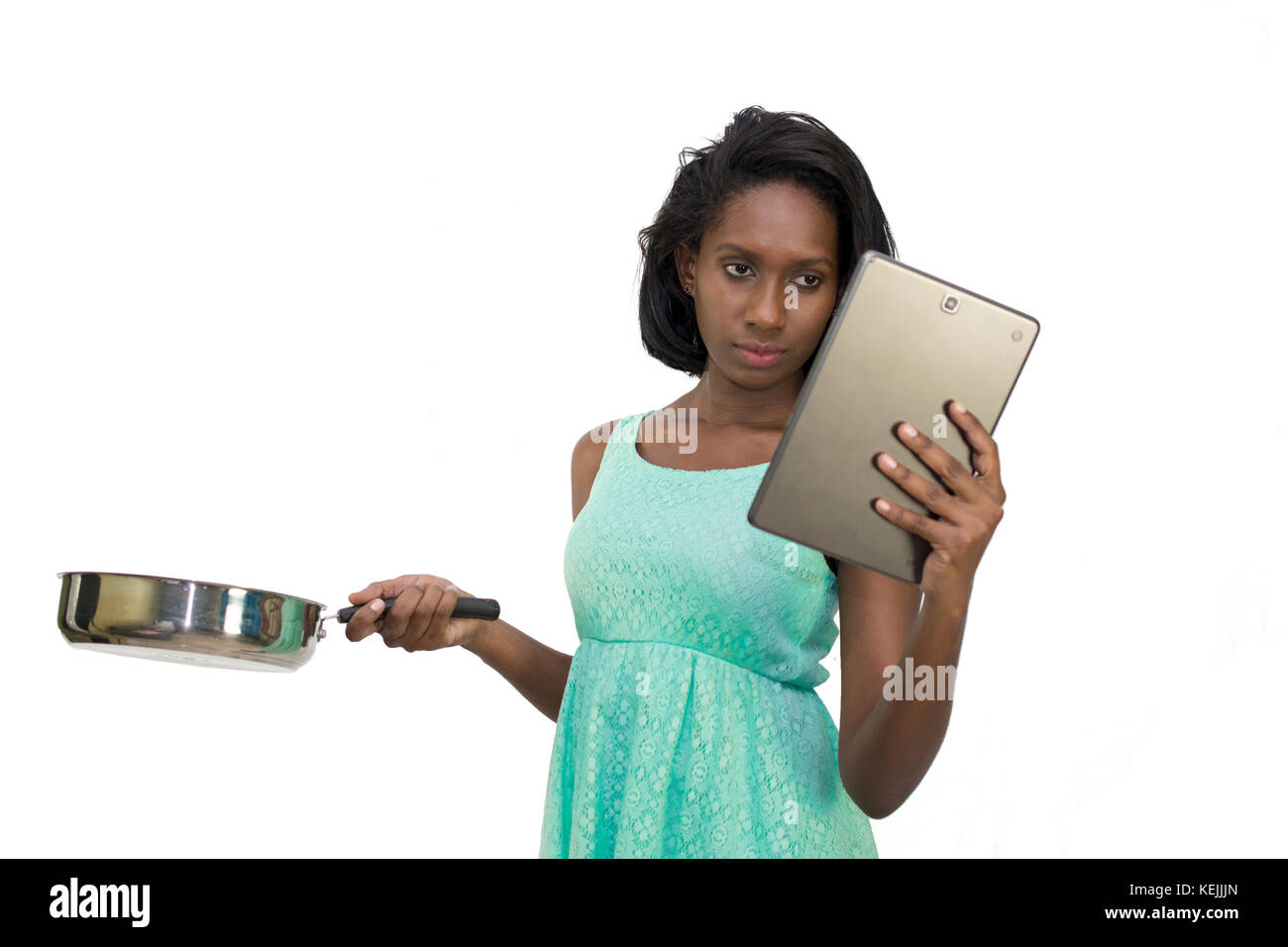 Woman holding pan and digital tablet Stock Photo