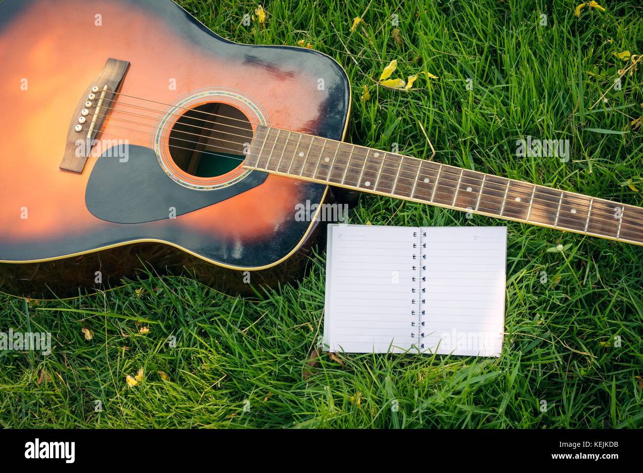 Paper for writing songs with a guitar on the lawn background Stock ...