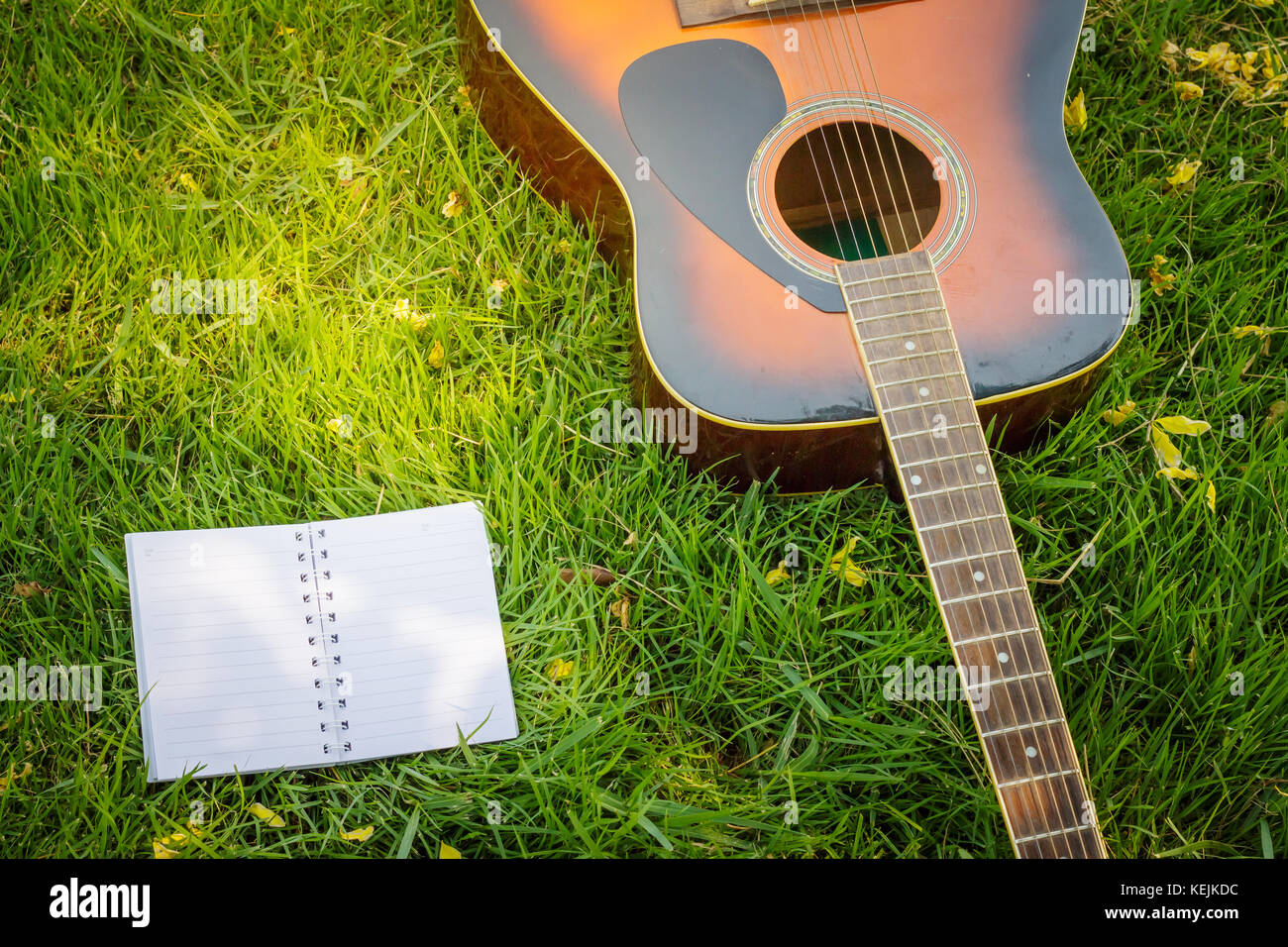 Paper for writing songs with a guitar on the lawn background Stock ...