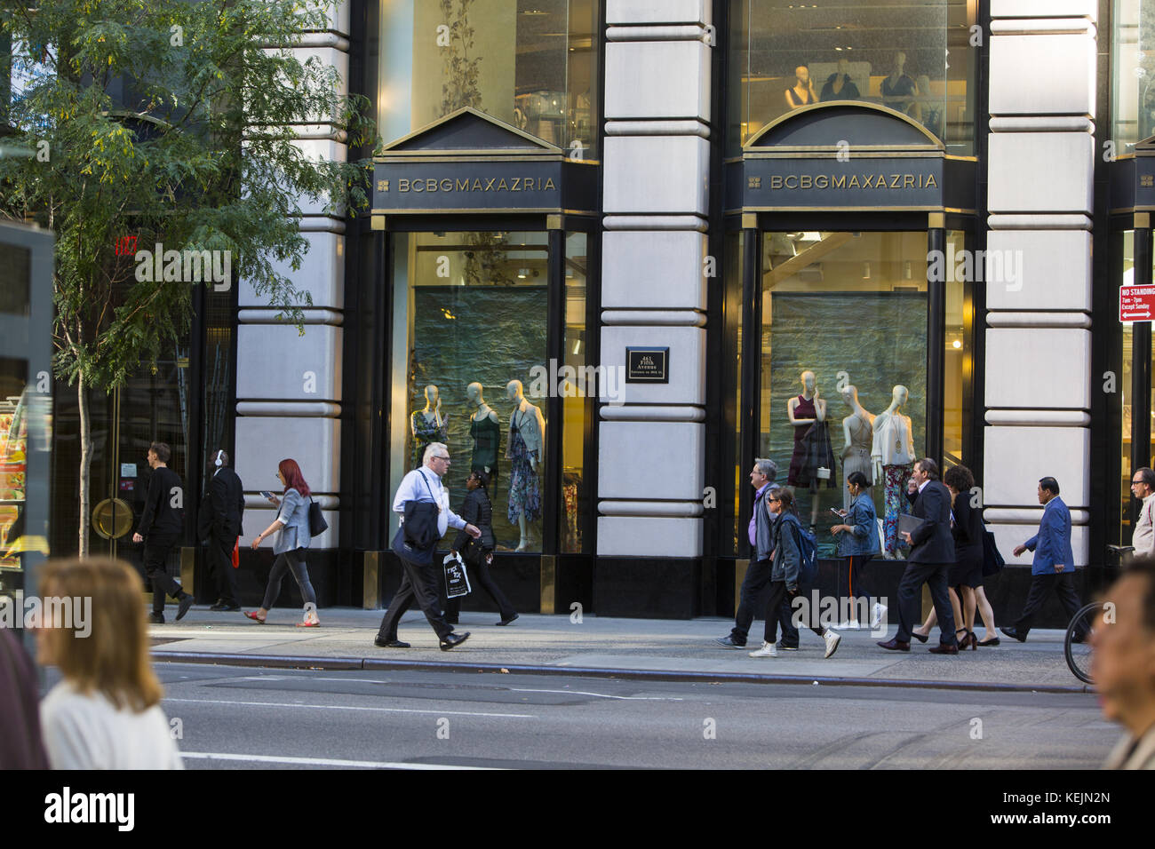 People walk by the upscale stores that line 5th Avenue in midtown ...