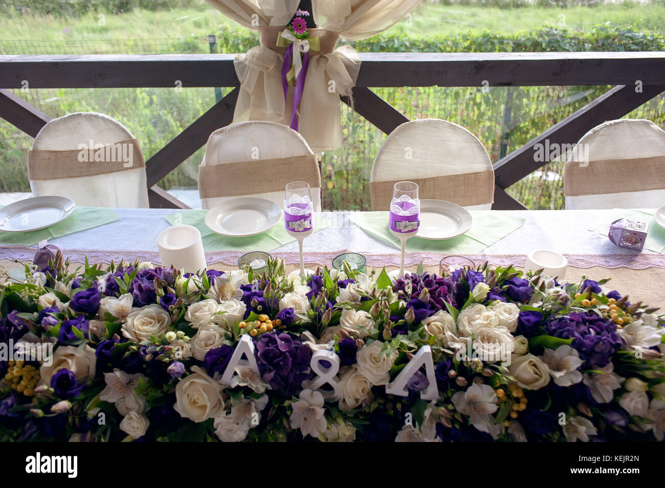 Beautifully decorated table for the wedding ceremony. Served banquet table decorated with fresh flowers in the open air. Stock Photo