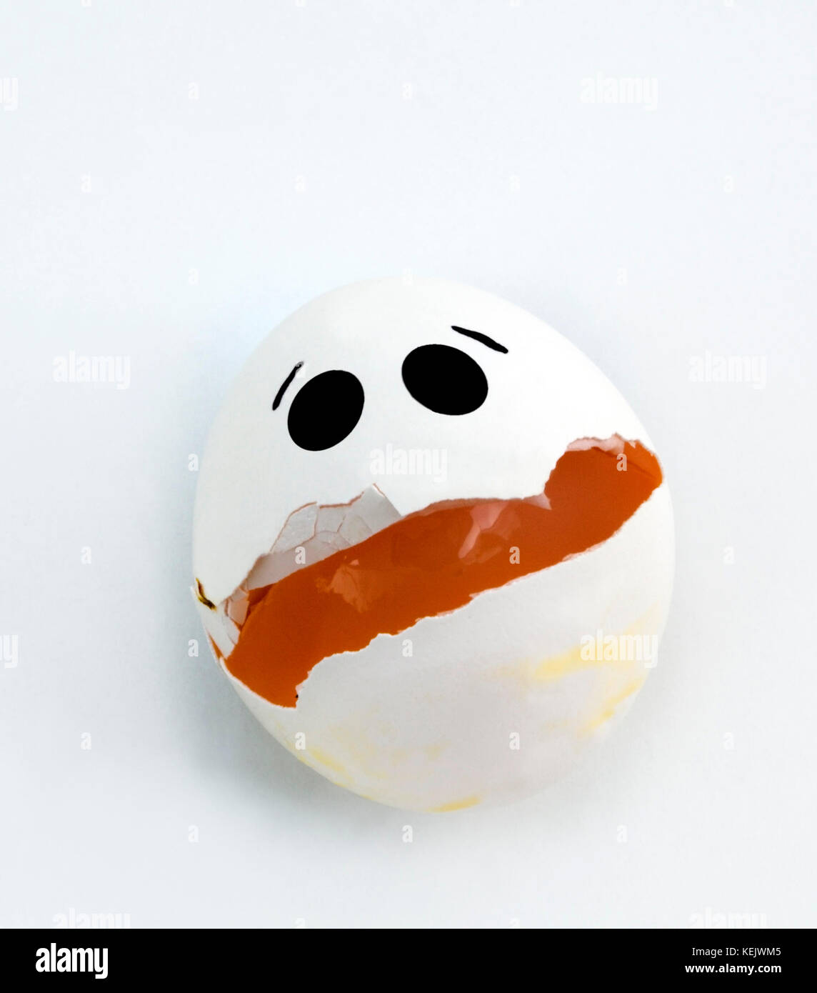 Cracked egg with sad expression. Stock Photo