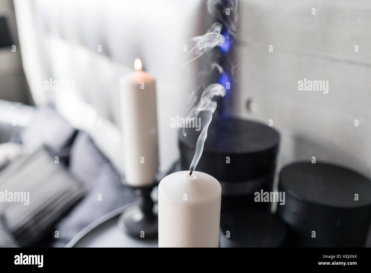 Extinguished candle in candlestick with smoke in bedroom Stock Photo