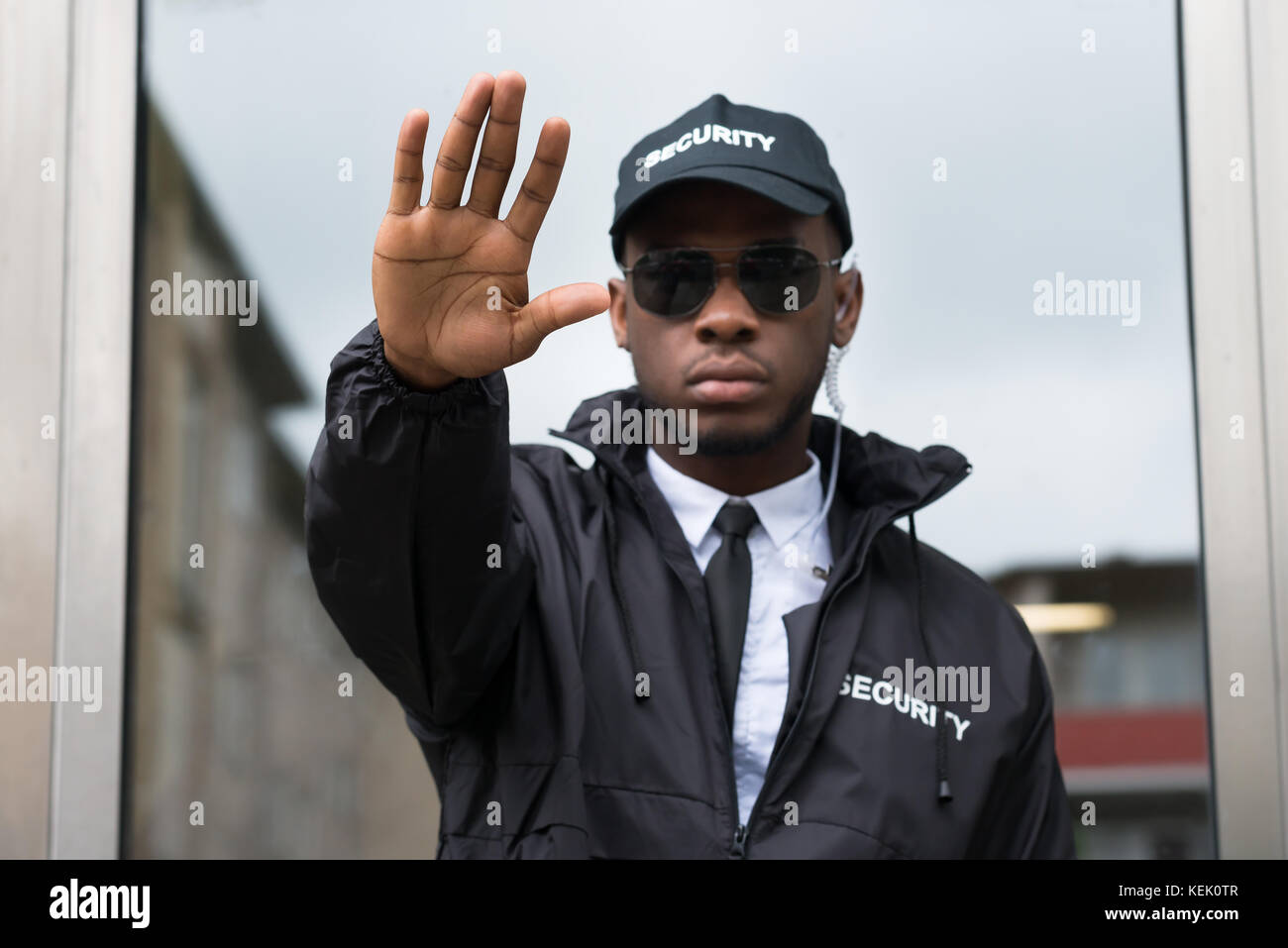 Confident Young African Male Security Guard Making Stop Gesture Stock Photo