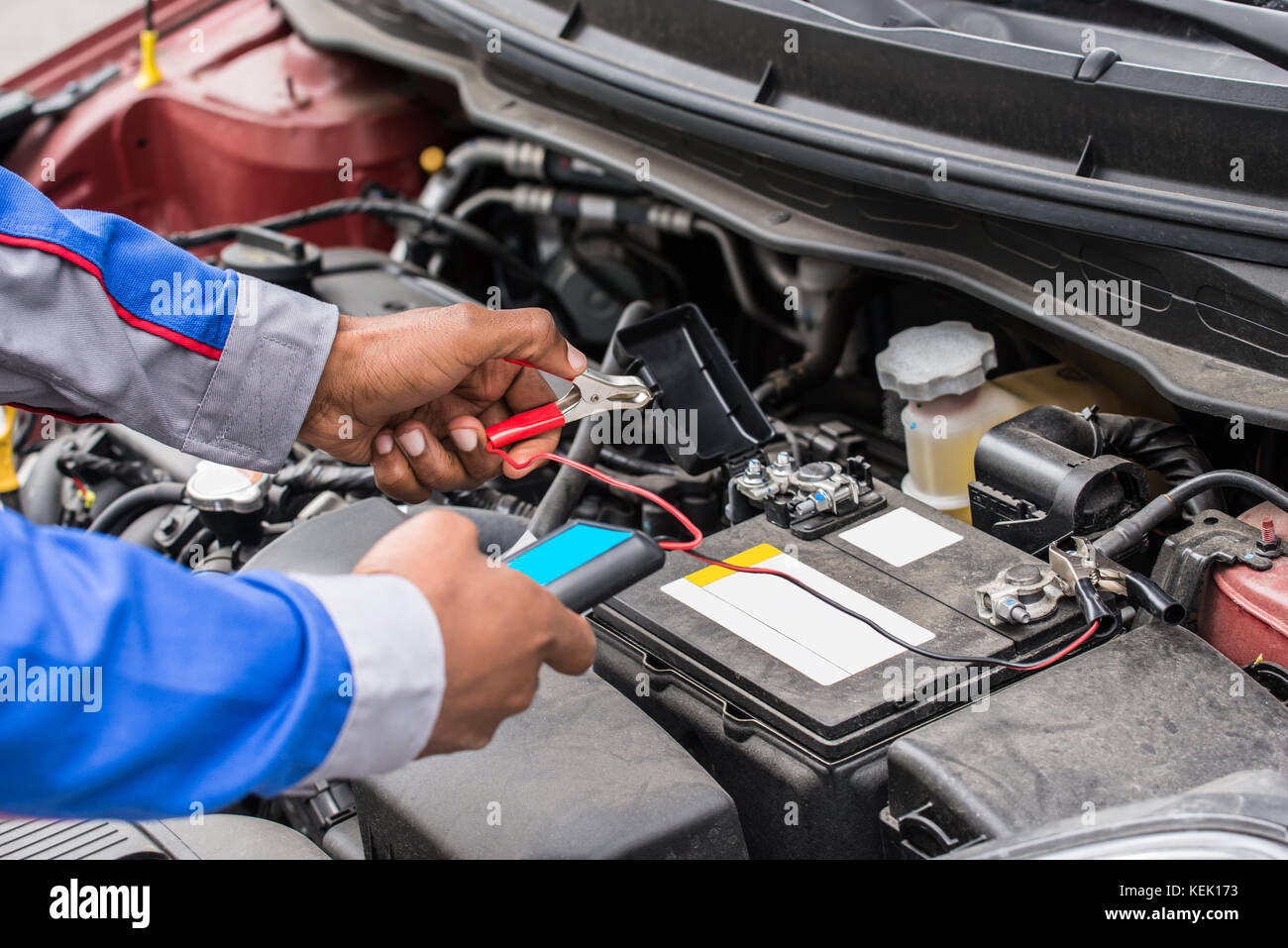 Close-up Of Mechanic Hands Using Multimeter For Checking Battery In Car Stock Photo