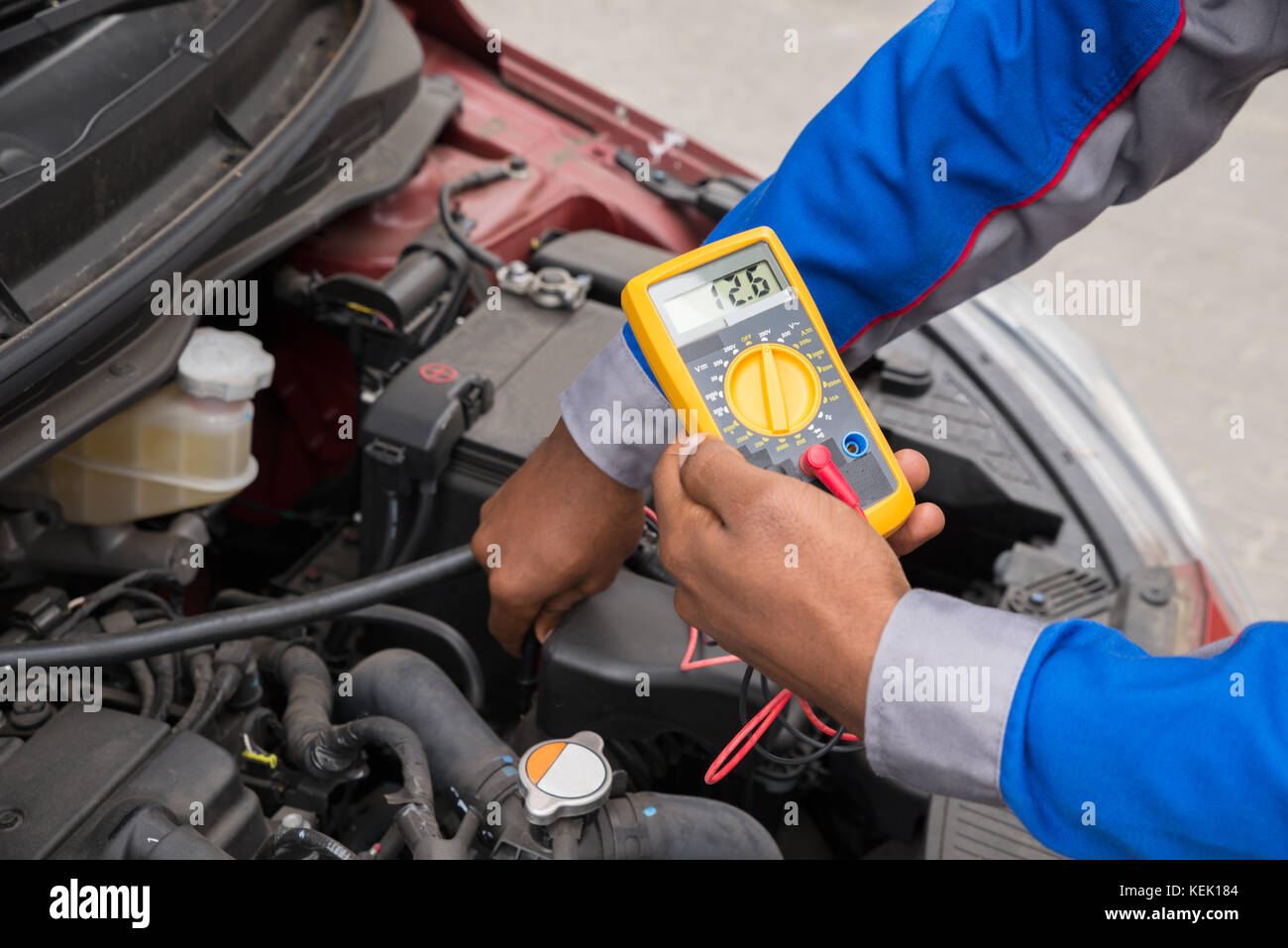 Close-up Of Mechanic Checking A Car Battery Level With Multimeter Stock Photo