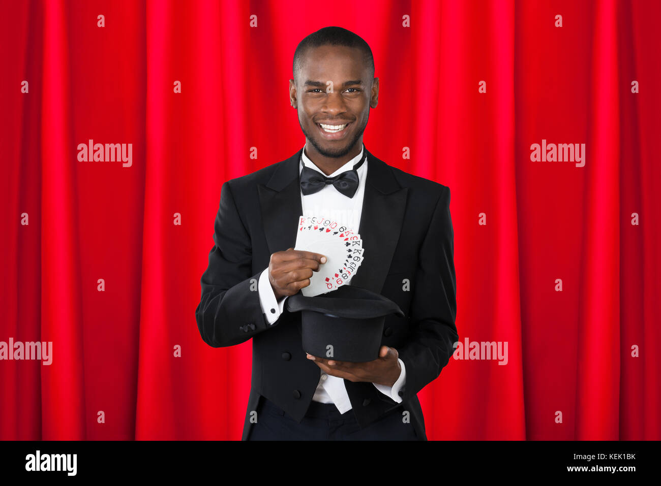 Young Happy Magician Showing Trick With Playing Cards Stock Photo