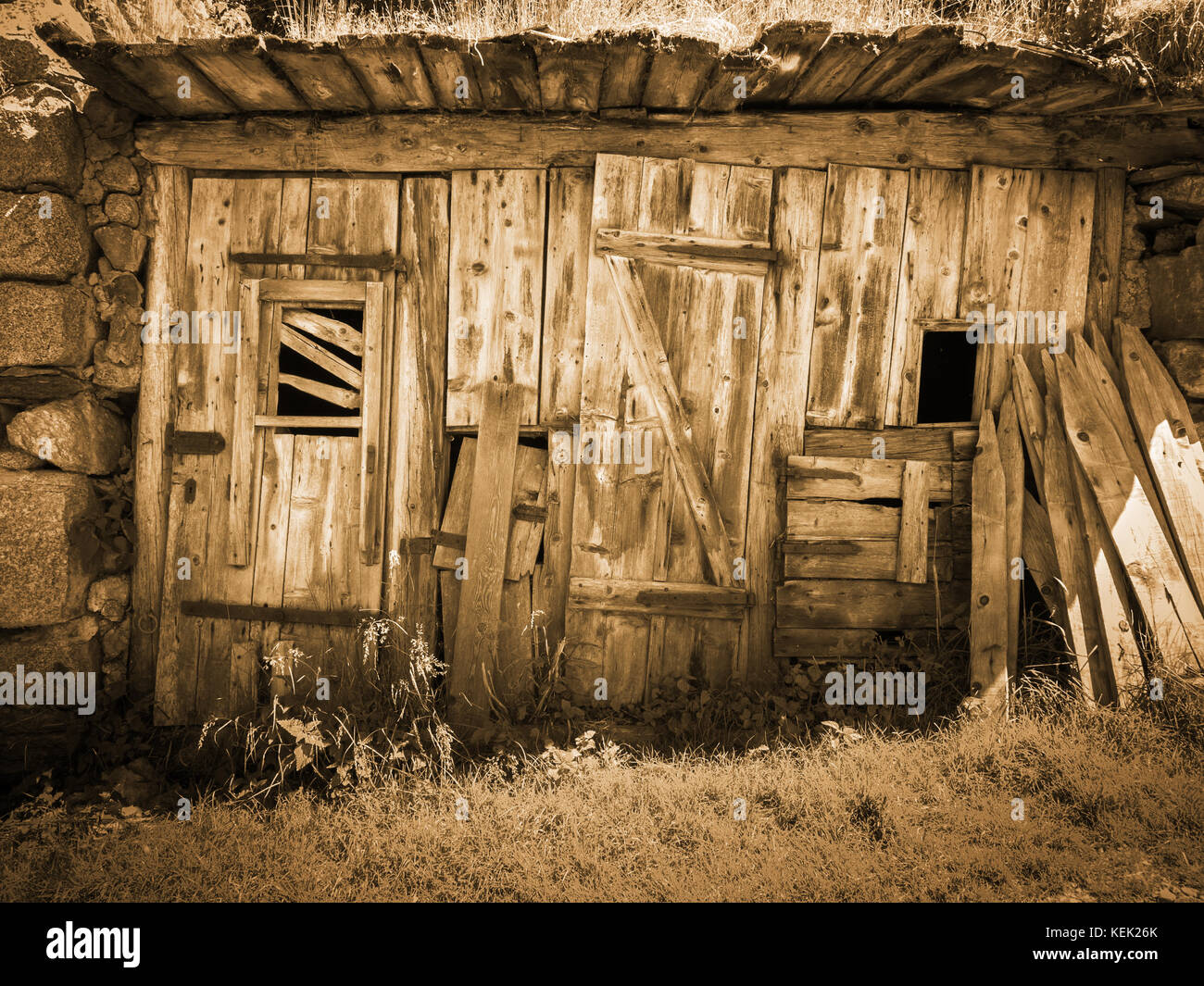 Frontal view of a decayed hut with doors and windows in South Tyrol above  the city of Merano/Italy; Sepia toned Stock Photo - Alamy