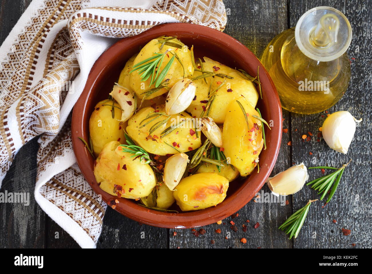 Oven cooked potato with rosemary, garlic, olive oil and mix of spices in a traditional ceramic
