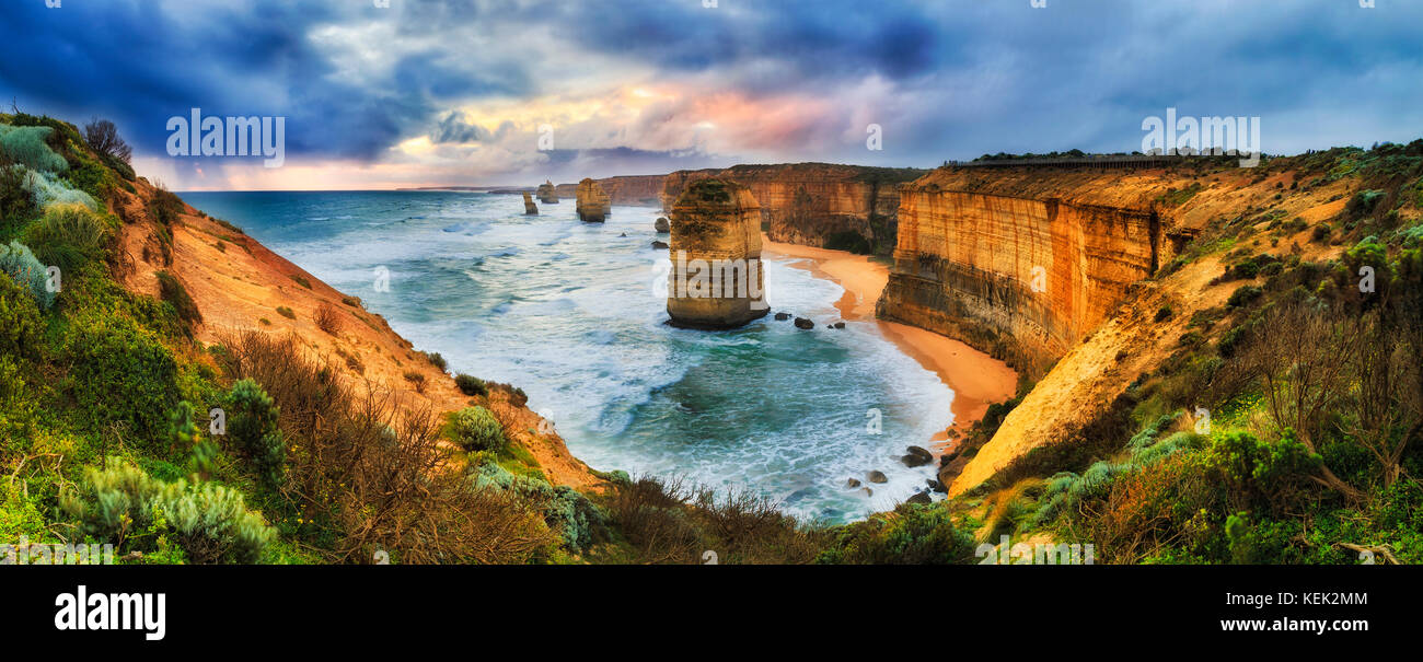 Stormy colourful sunset over twelve apostles marine park on Great Ocean road from lookout towards limestone standing eroded apostle rocks. Stock Photo