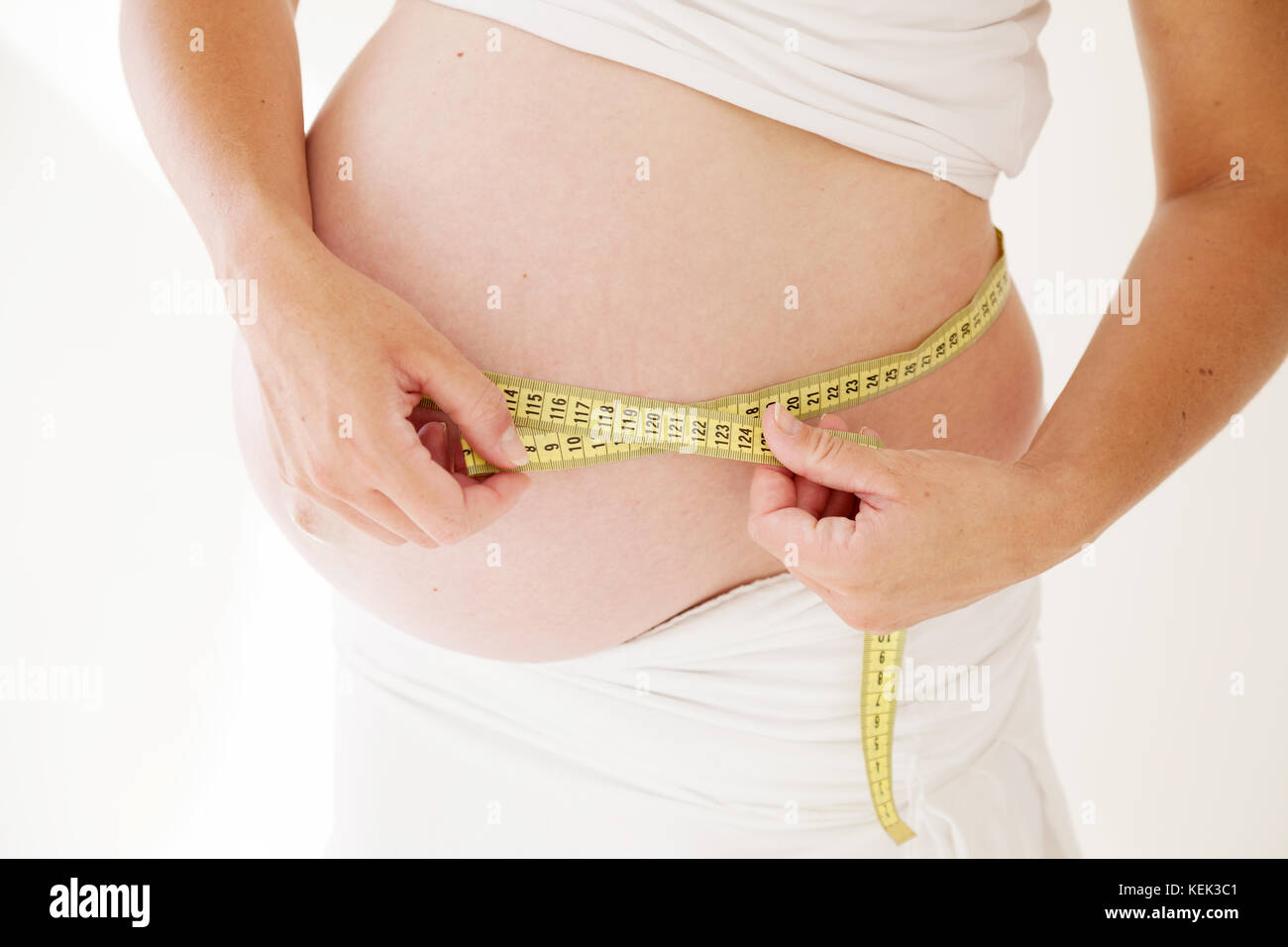 the stomach of a pregnant woman and a measuring tape Stock Photo
