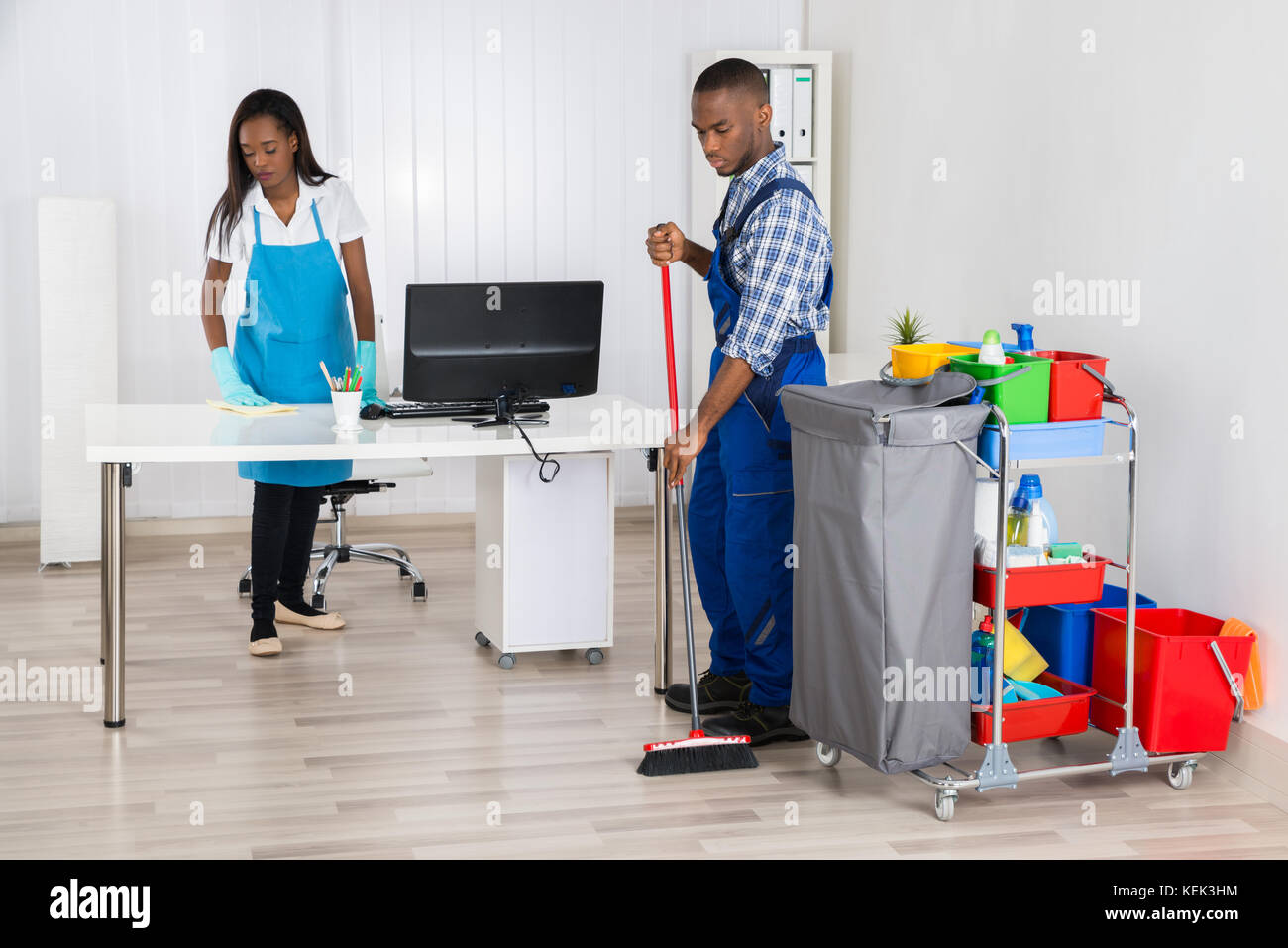 Young African Male And Female Cleaners Cleaning Office Stock Photo Alamy